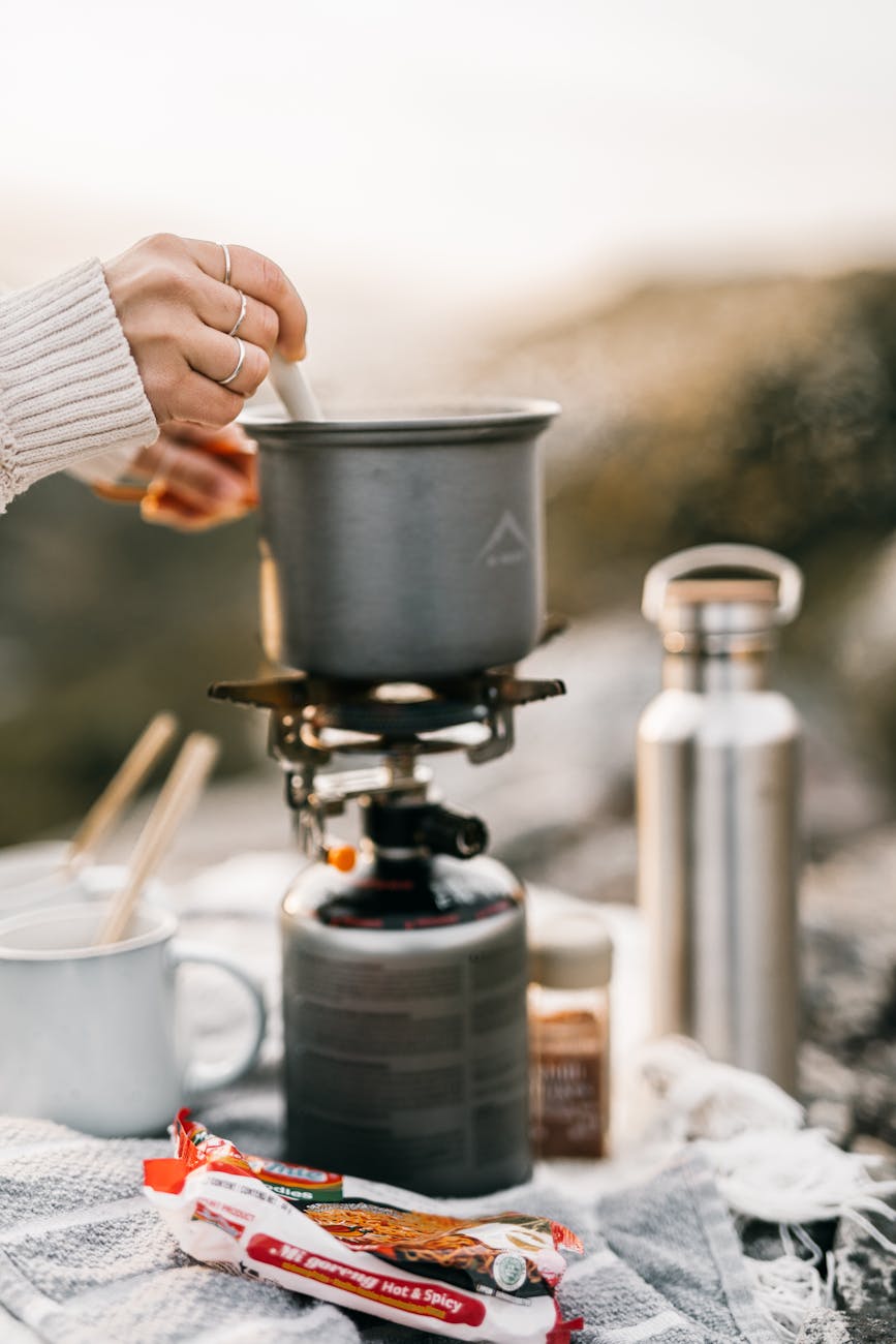 a person cooking on a portable stove